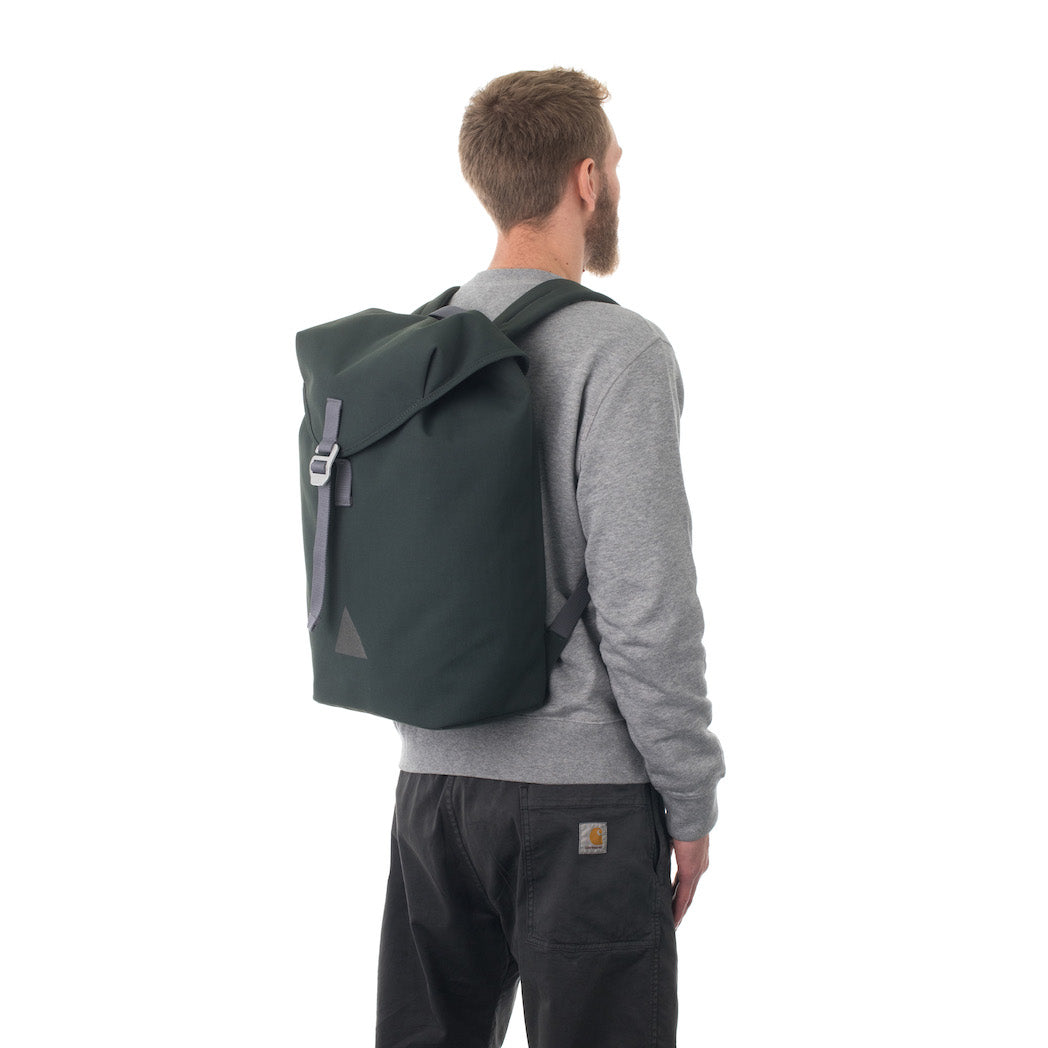 Man carrying grey flap backpack.