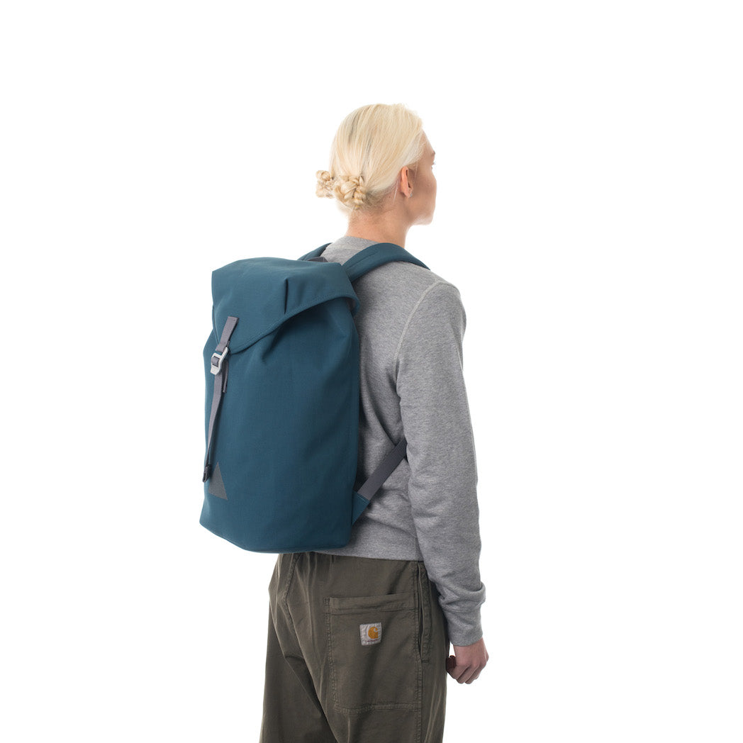 Woman carrying blue flap backpack.