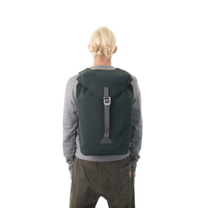 Woman carrying grey waterproof flap backpack.