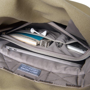 Khaki backpack interior organiser pocket with guidebook and earphones.