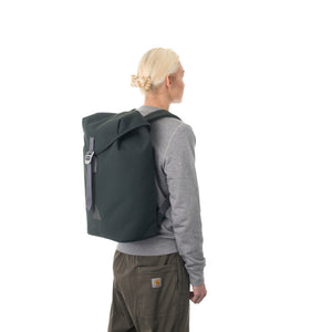 Woman carrying grey flap backpack.