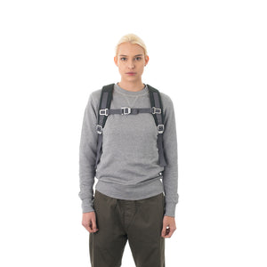 Woman carrying grey backpack with padded shoulder straps.