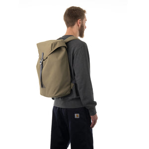 Man carrying khaki flap backpack.