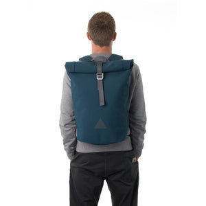 Man carrying blue waterproof rolltop backpack.