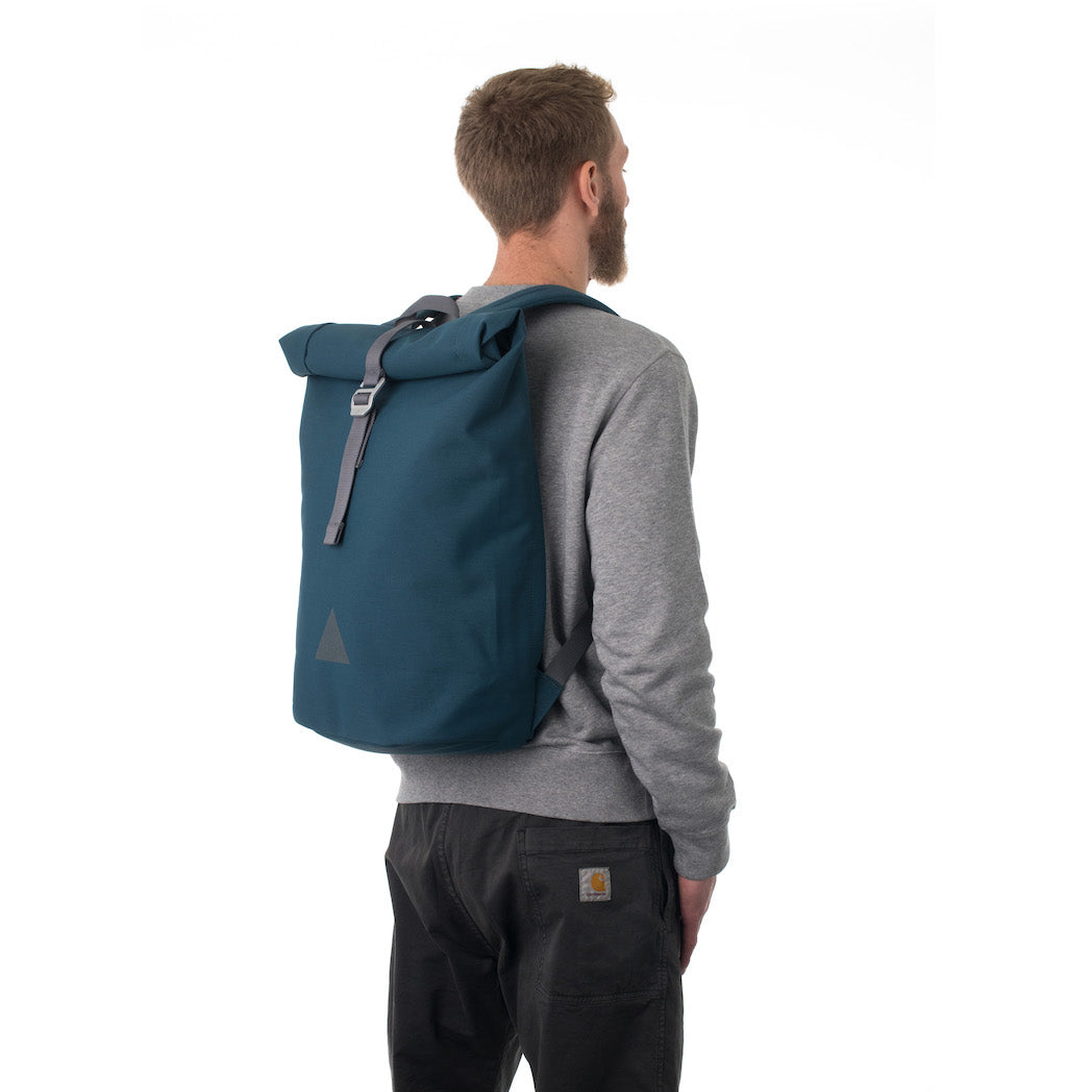 Man carrying blue rolltop backpack.