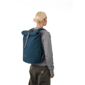 Woman carrying blue rolltop backpack.