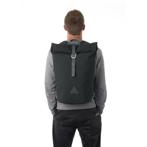 Man carrying grey waterproof rolltop backpack.