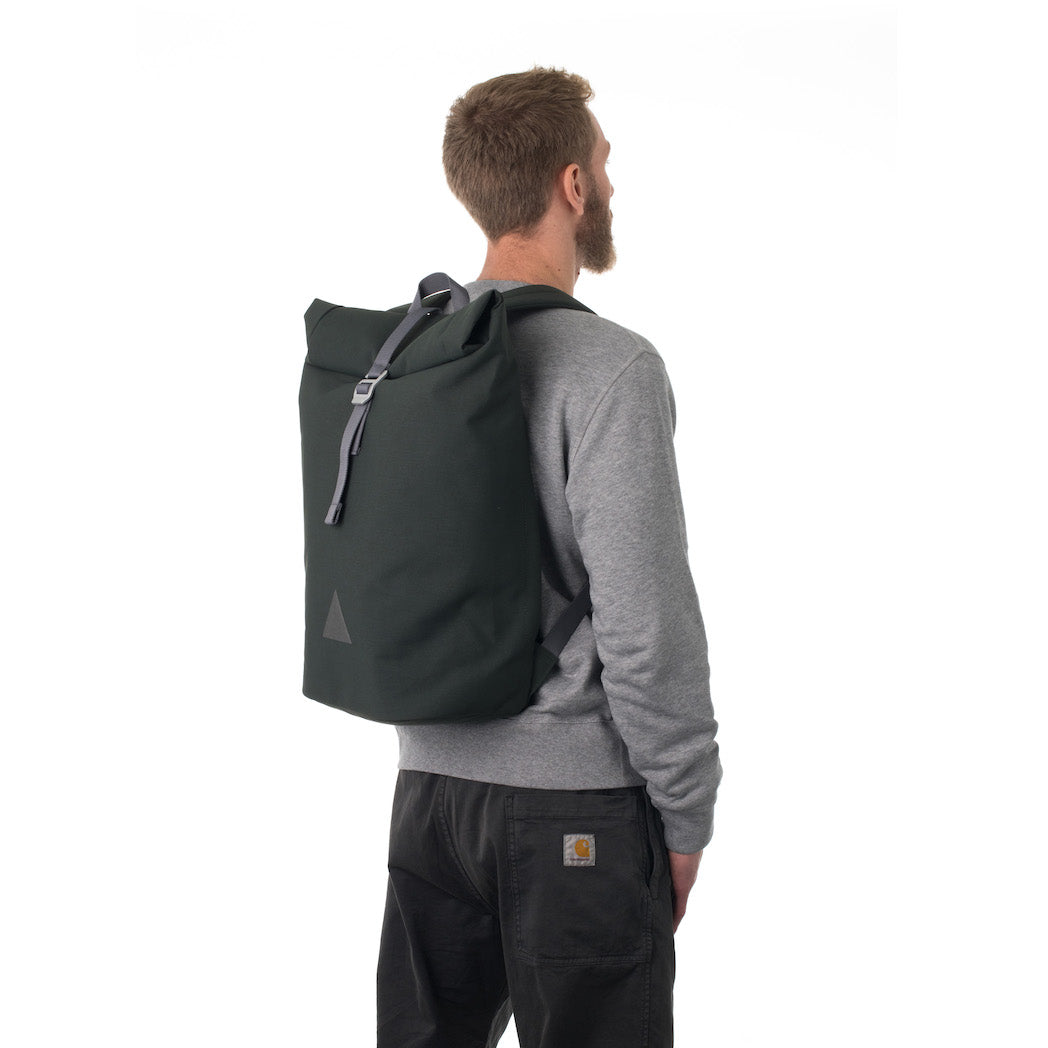 Man carrying grey rolltop backpack.