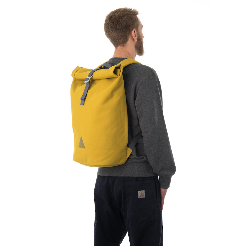 Man carrying yellow rolltop backpack.