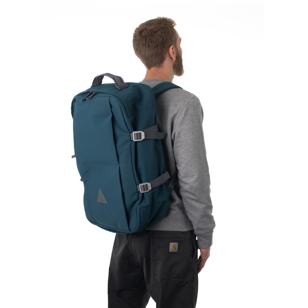 Man carrying blue travel backpack.
