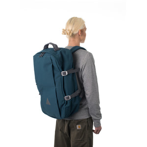 Woman carrying blue travel backpack.