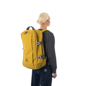 Woman carrying yellow travel backpack.