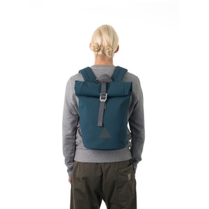 Woman carrying blue waterproof rolltop backpack.