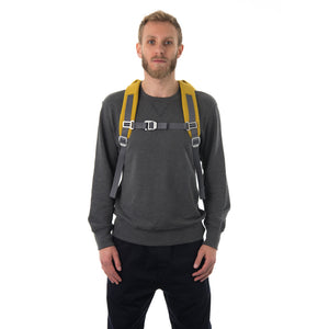Man carrying yellow backpack with padded shoulder straps.