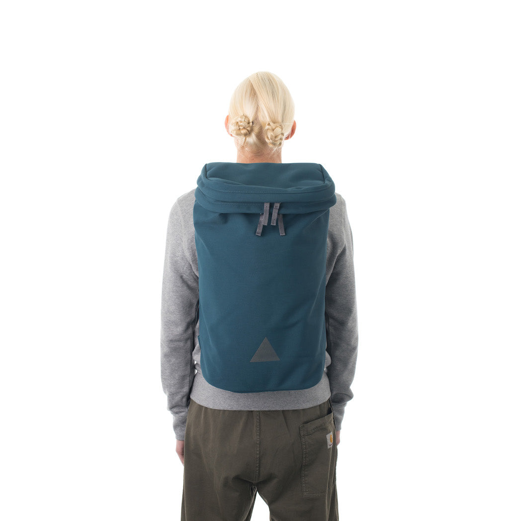 Woman wearing large blue backpack with triangle logo.