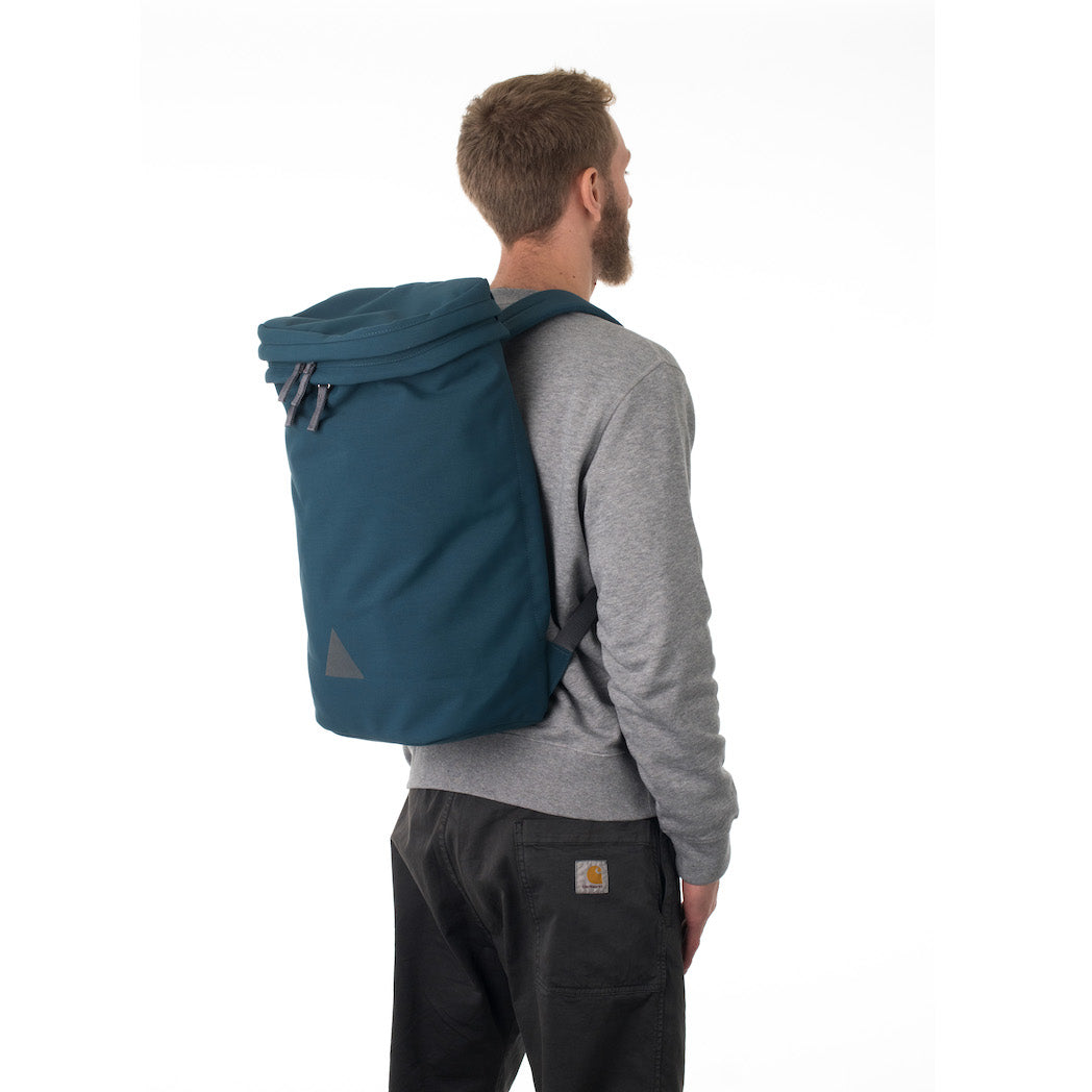 Man wearing large blue canvas backpack.