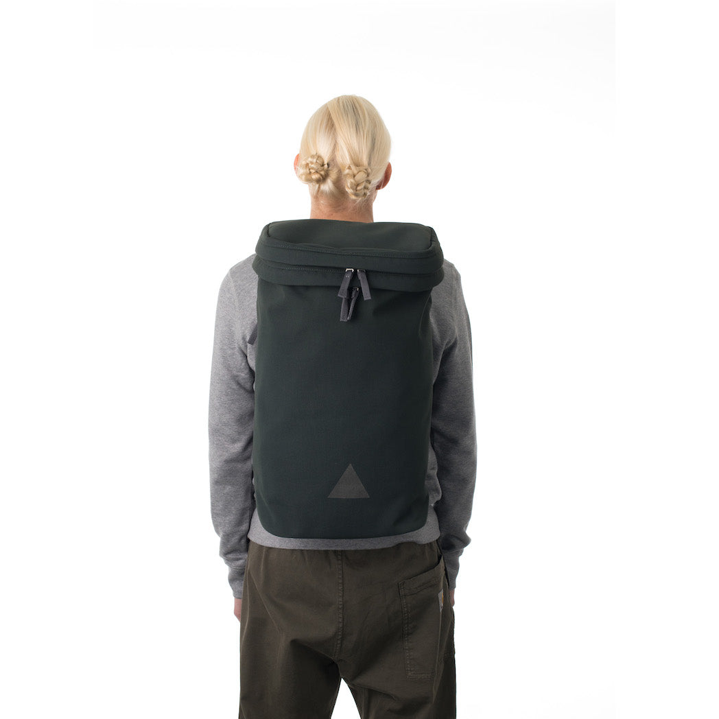 Woman wearing large grey backpack with triangle logo.