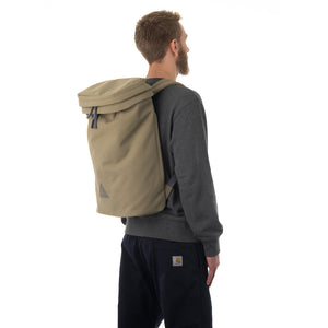 Man wearing large khaki canvas backpack.