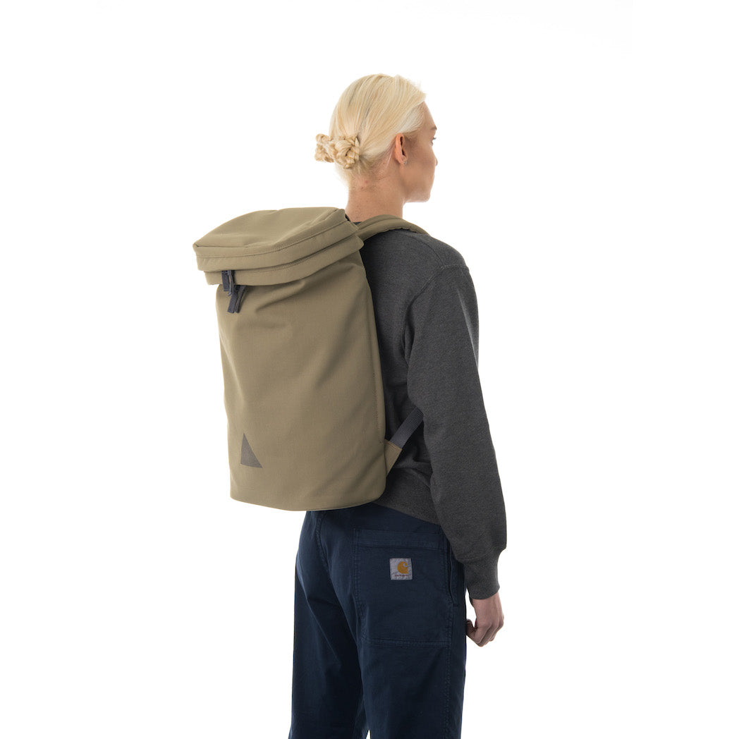 Woman wearing large khaki backpack.