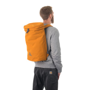 Man wearing large orange canvas backpack.